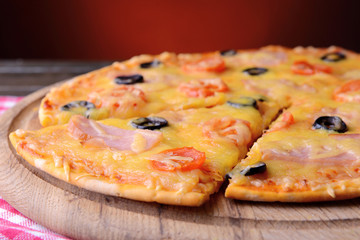 Tasty pizza on table on dark red background