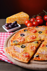 Tasty pizza on table on dark red background