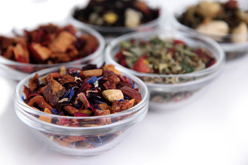 Different kinds of dry tea in bowls close up