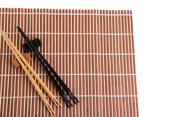 Chopsticks  on bamboo mat, isolated on white background