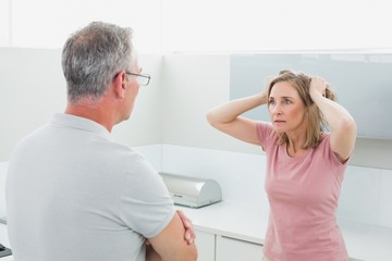 Unhappy couple having an argument in kitchen