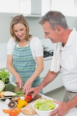 Happy couple preparing food together in kitchen