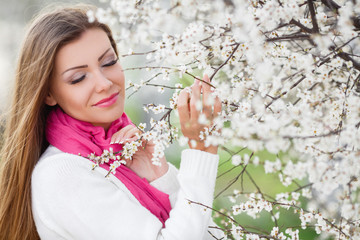 portrait of young brunette in the spring blooming garden