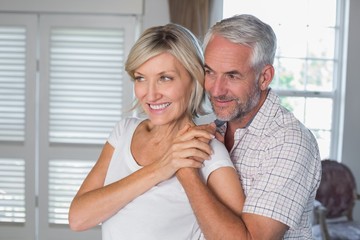 Obraz na płótnie Canvas Smiling mature man embracing woman