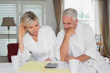 Couple sitting with home bills and calculator