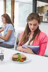 Woman using digital tablet in coffee shop