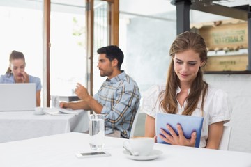Woman using digital tablet in coffee shop