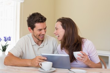 Couple using digital tablet while having coffee