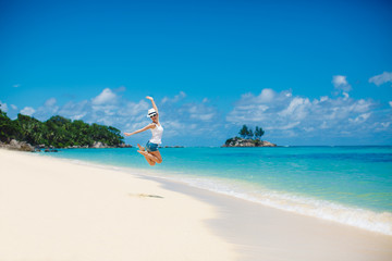 summer, laughing woman jumping on the beach