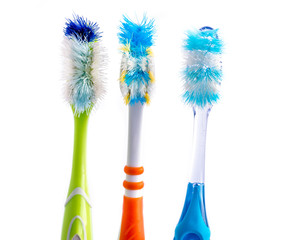 Old used colorful toothbrushes isolated on white background