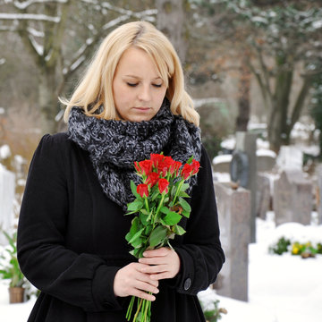 Frau trauert auf Friedhof