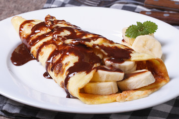 pancake with banana, mint and chocolate on the table
