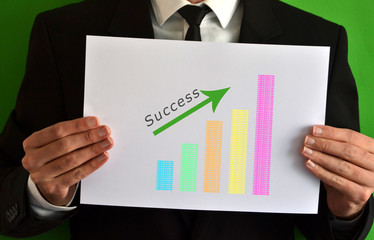 Businessman showing a sheet with a bar chart symbol and success