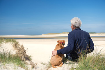 Naklejka na ściany i meble Man with dog on sand dune