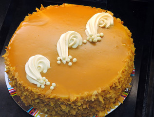 Caramel cheesecake decorated with vanilla frosting curls.