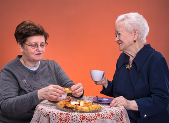 Mother having tea or coffee with her daughter