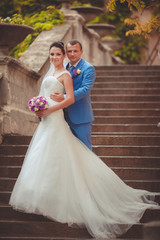 Bride and groom at wedding day kiss in park, retro grain