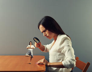 woman looking through loupe at woman