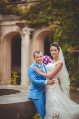 Naklejka premium Bride and groom at wedding day kiss in park, retro grain