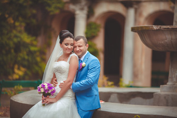 Bride and groom at wedding day kiss in park, retro grain