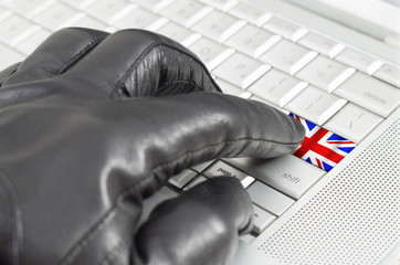 Hacking UK concept with hand wearing black leather glove pressin