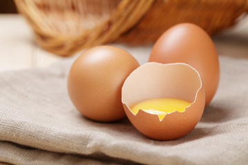 raw chicken eggs one open with yolk
