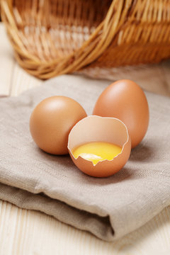 raw chicken eggs one open with yolk
