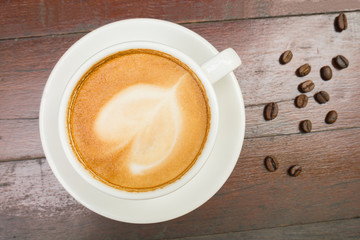 Coffee cup and beans on wooden table