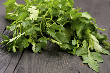 Green parsley lying on a dark brown table.