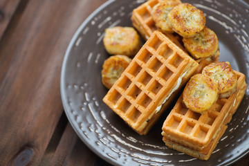 Waffles served with grilled banana, wooden background