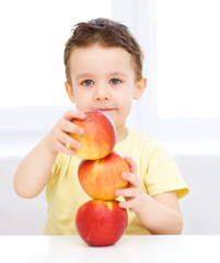 Portrait of a happy little boy with apples