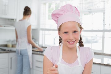 Close-up of a young girl wearing chef's hat in kitchen