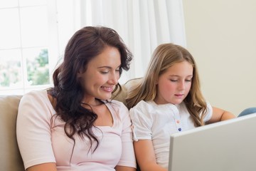 Mother and daughter using laptop