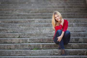 Fototapeta premium young woman sitting on the stairs of office building
