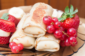 Stuffed pancakes and fresh strawberry with redcurrant