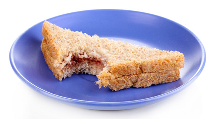 Bitten sandwich with jam on plate isolated on white
