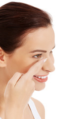 Fototapeta premium Woman putting contact lens in her eye
