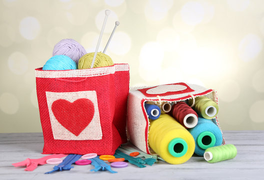 Bags with bobbins of colorful thread and woolen balls