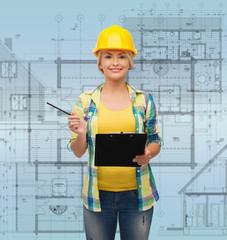 smiling woman in helmet with clipboard