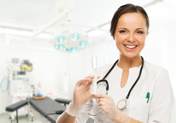 Young positive brunette doctor woman with syringe 