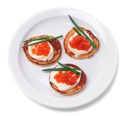 Pancakes with red caviar on plate, isolated on white