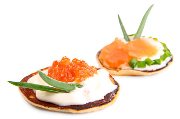 Pancakes with red caviar and salmon,  isolated on white