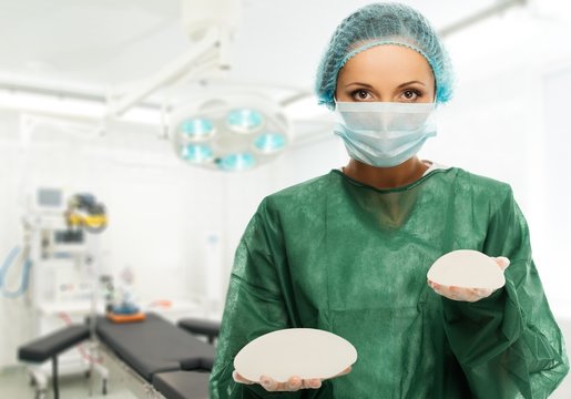 Plastic surgeon woman holding different size silicon breast 