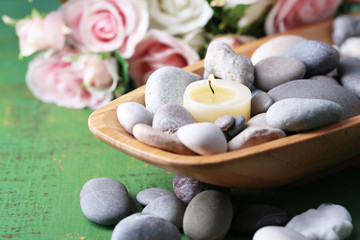 Wooden bowl with spa stones and candles