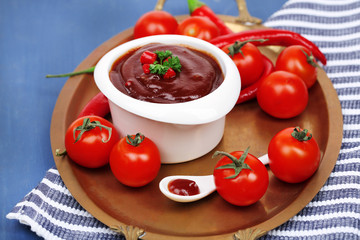 Tomato sauce in bowl on wooden table close-up