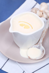 Delicate sauce in pitcher on wooden table close-up