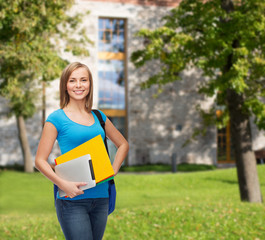 smiling student with bag, folders and tablet pc