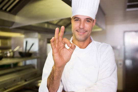 Male cook gesturing okay sign in kitchen - Powered by Adobe