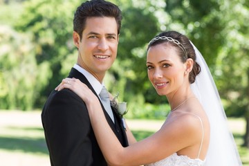 Bride and groom smiling in garden
