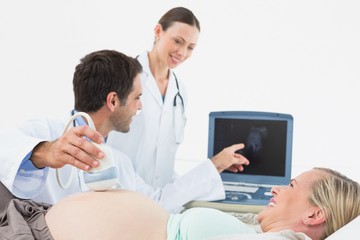 Fototapeta premium Smiling pregnant blonde having an ultrasound scan